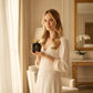 Woman holding House of DaVoice Marshmallow Halo perfume that smells like marshmallows