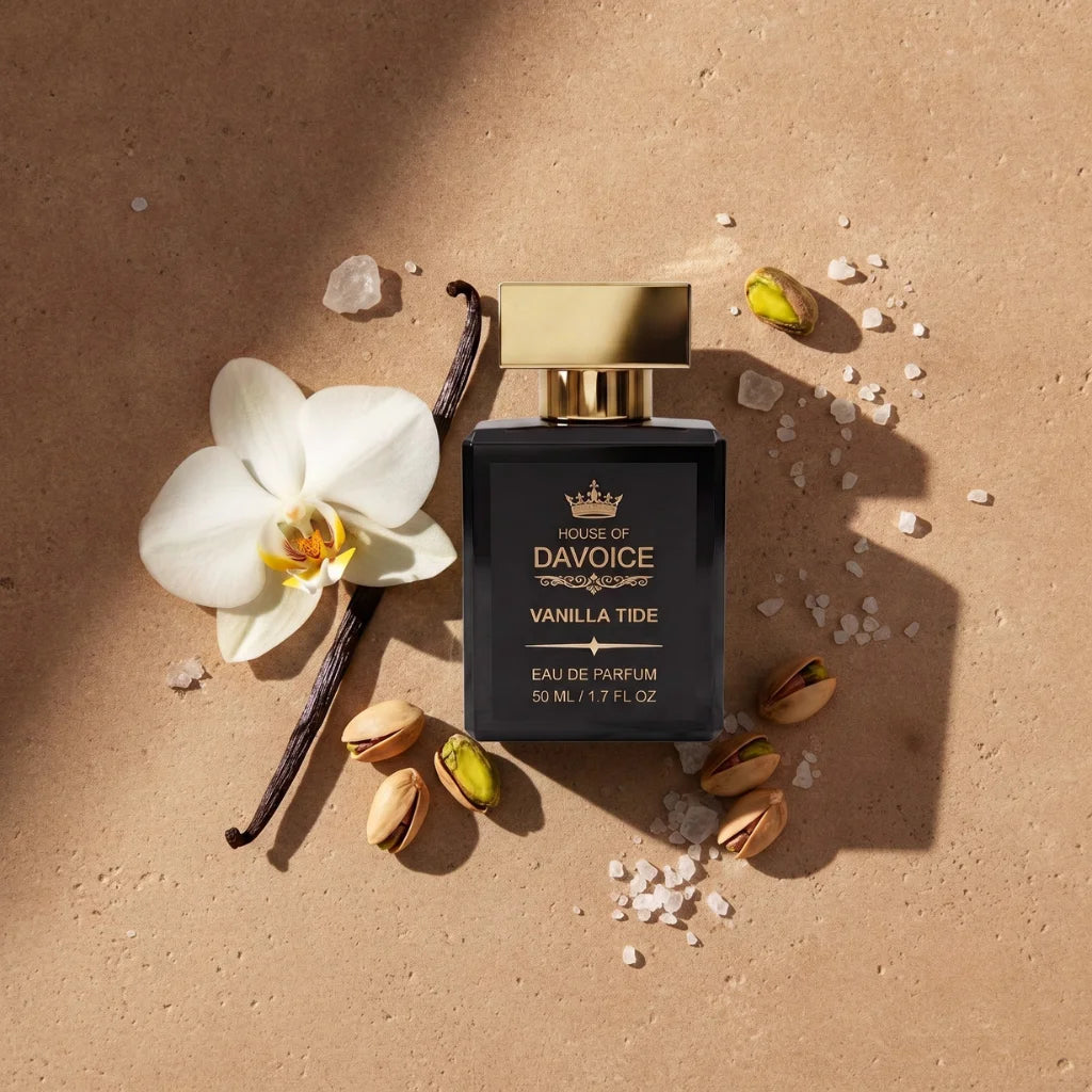 A perfume bottle labeled 'House of DaVoice Vanilla Tide Eau de Parfum' is arranged on a warm beige surface with a white flower, vanilla bean, pistachios, and sea salt scents