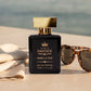 Vanilla Tide luxury perfume beside sunglasses and linen near the ocean